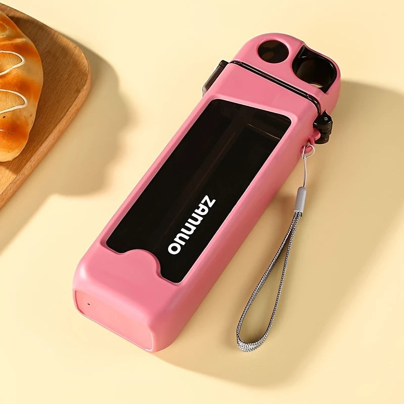 Pink 350ml sports water bottle with black label and wrist strap on beige surface